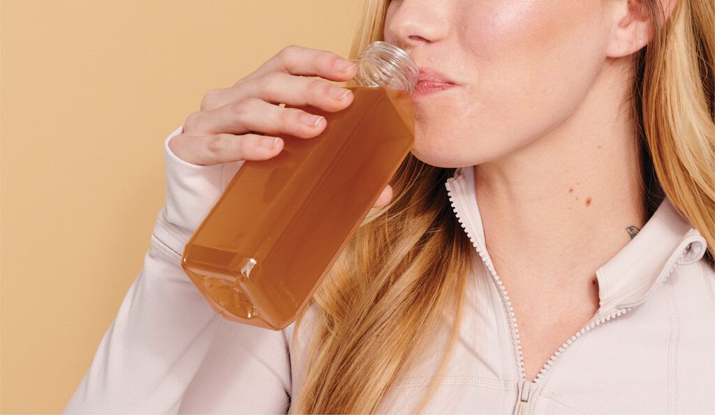 Woman drinking CBD water after doing yoga